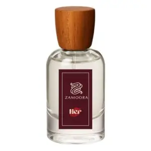 Zamoora HER perfume bottle for women placed among pink flowers with a purple background, highlighting fruity top notes of strawberry, raspberry, blackberry, sour cherry, black currant, mandarin orange and lemon, a heart note of violet jasmine, and base notes of musk, vanilla, cashmeran, woody notes, amber, oakmoss and patchoulI.
