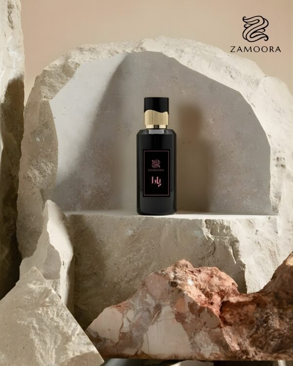 Zamoora Yaara women’s perfume bottle placed on a purple podium with lilac flowers around it, highlighting top notes of frankincense, cardamom, mandarin oil and apple, heart notes of lavender, caramel, orange blossom and rose, and base notes of Madagascar vanilla, musk, guaiac wood, ambrox and norlimbanol.